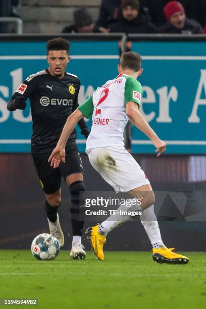 Jadon Sancho of Borussia Dortmund and Stephan Lichtsteiner of FC Augsburg battle for the ball during the Bundesliga match between FC Augsburg and...