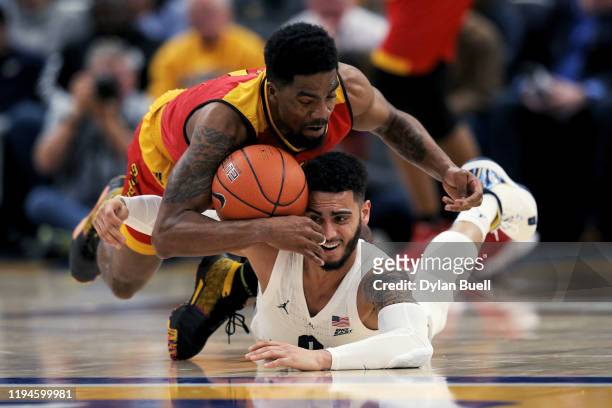 Anthony Gaston of the Grambling State Tigers and Markus Howard of the Marquette Golden Eagles battle for a loose ball in the first half at the Fiserv...