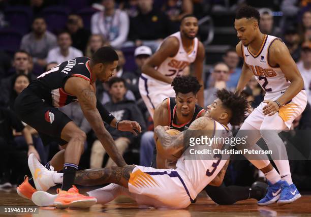 Kelly Oubre Jr. #3 of the Phoenix Suns battles for a loose ball with Hassan Whiteside of the Portland Trail Blazers as Kent Bazemore and Elie Okobo...