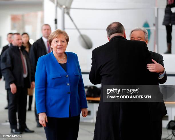 Secretary of State Mike Pompeo embraces Secretary-General of the United Nations Antonio Guterres as German Chancellor Angela Merkel looks on upon...