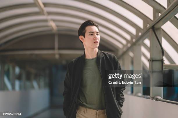 an asian chinese young man walking out from the sub way station in the day smiling - male fashion model stock pictures, royalty-free photos & images
