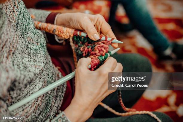 senior woman hands knitting a xmas sweater - lavorare a maglia foto e immagini stock