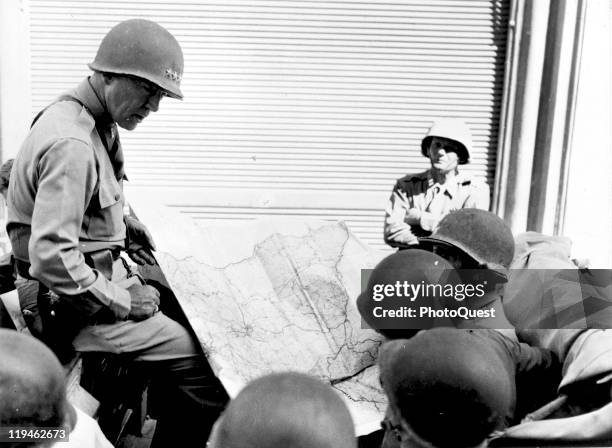 American military commander Lieutenant General George S. Patton , Commander of the US 7th Army, confers with unidentified officers during the...