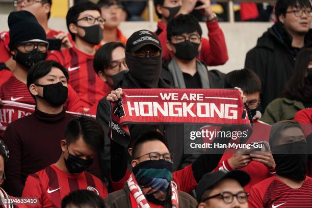 Hong Kong supporters surrounded by security guards during the EAFF E-1 Football Championship match between Hong Kong and China at Busan Asiad Main...