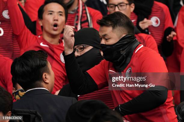 Hong Kong supporters surrounded by security guards during the EAFF E-1 Football Championship match between Hong Kong and China at Busan Asiad Main...