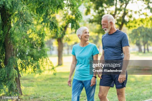 seniorenpaar entspannt sich nach dem joggen - power walking stock-fotos und bilder