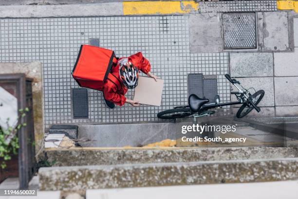 man levert pizza in stad - food delivery stockfoto's en -beelden