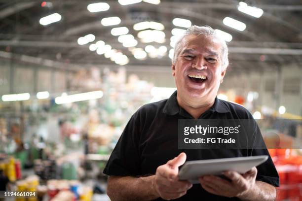 portret van een manager met behulp van digitale tablet in een fabriek - factory owner stockfoto's en -beelden