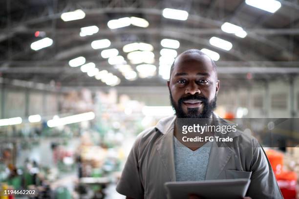 porträt eines managers mit digitalem tablet in einer fabrik - employee engagement stock-fotos und bilder