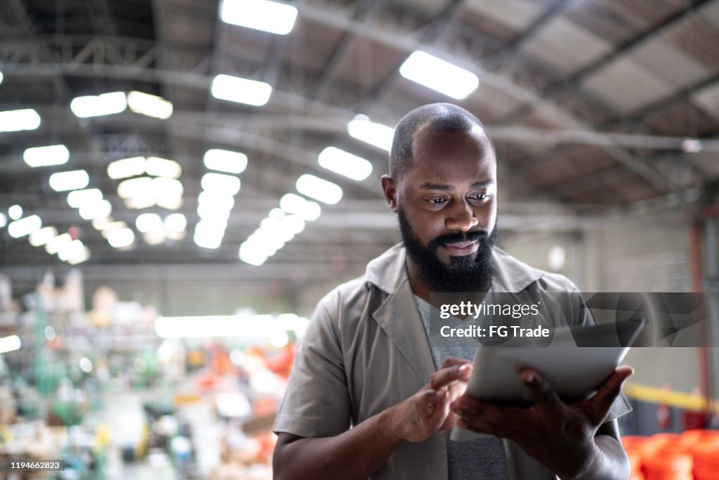 Focused manager using digital tablet in a factory