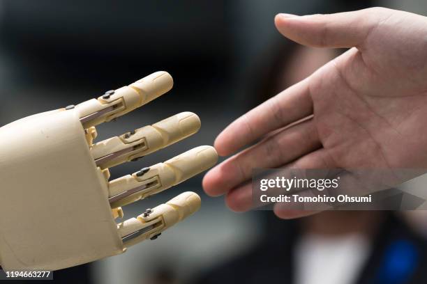 An attendee shakes hands with the Shiorin announce robot at the International Robot Exhibition on December 18, 2019 in Tokyo, Japan. IREX...