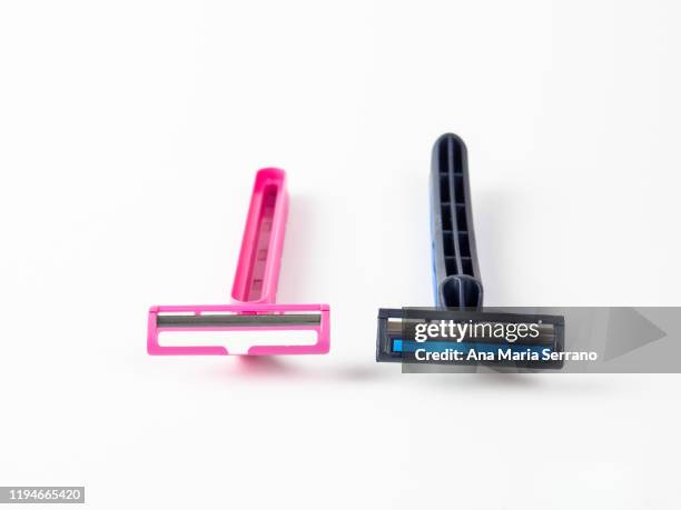 pink disposable razor and blue disposable razor on a white background - vello pubico fotografías e imágenes de stock