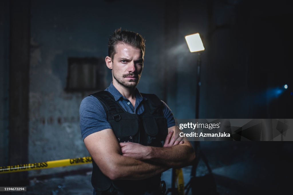 Portrait of Male Police Officer at Urban Crime Scene
