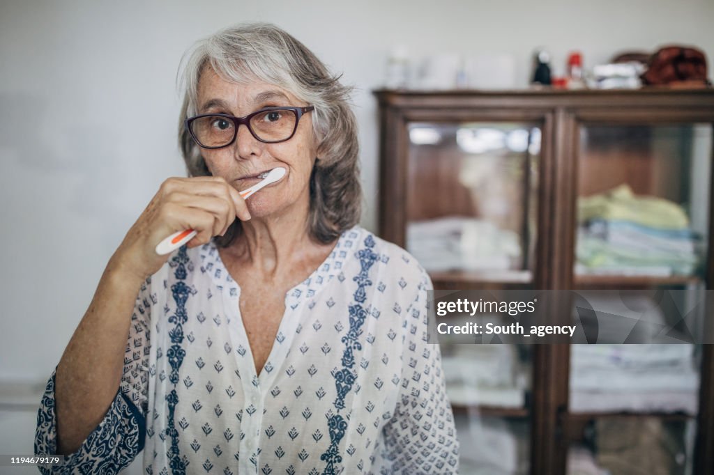 Senior vrouw tanden poetsen in de badkamer