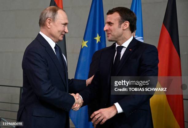 Russian President Vladimir Putin and French President Emmanuel Macron shake hands on their way to the family picture during the Peace summit on Libya...