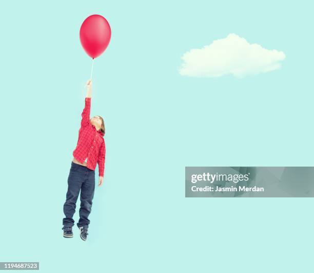 boy flying on balloon - child balloon studio photos et images de collection
