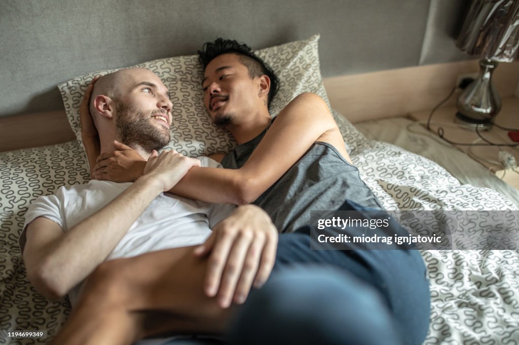 Gay couple enjoying in bed during weekend morning