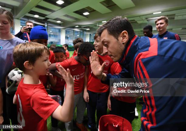 Mesut Ozil of Arsenal meets children during an Arsenal Community Coaching session in The Hub at at Emirates Stadium on December 18, 2019 in London,...