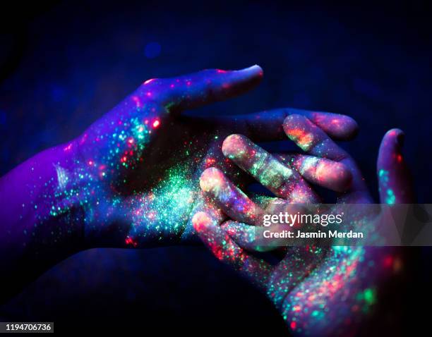 abstract. art. hands. ultraviolet. particles. universe. - fluorescent stock-fotos und bilder