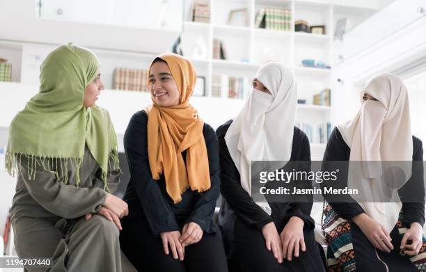 group of muslim women and girls at home - schleier stock-fotos und bilder