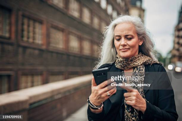 Senior woman in the city using phone