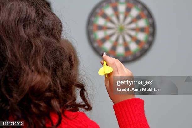 young girl playing dartboard game in her room - dart stock pictures, royalty-free photos & images