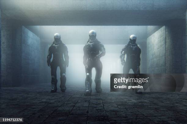 futuristic police cyborgs walking in old corridor - cyborg stock pictures, royalty-free photos & images