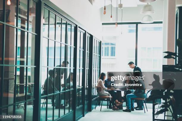 business meeting in co-working space - singapore office stock pictures, royalty-free photos & images