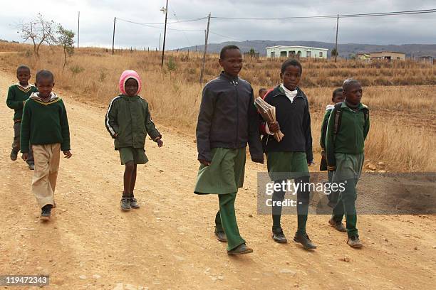 School children walk home near the southern rural village in Sibovu on July 13, 2011. More than 100,000 children in Swaziland rely on government...