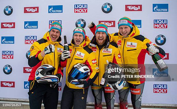 First-placed German team, Friedrich Francesco with Margis Thorsten Schueller Alexander Bauer Candy pose on the podium after the 4-man bobsleigh event...