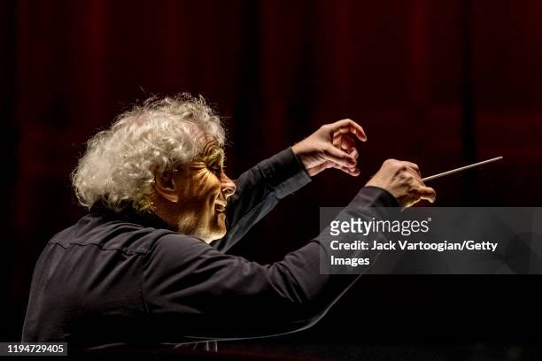 View, from behind, of British conductor Sir Simon Rattle during the final dress rehearsal prior to the season revival of the Metropolitan...