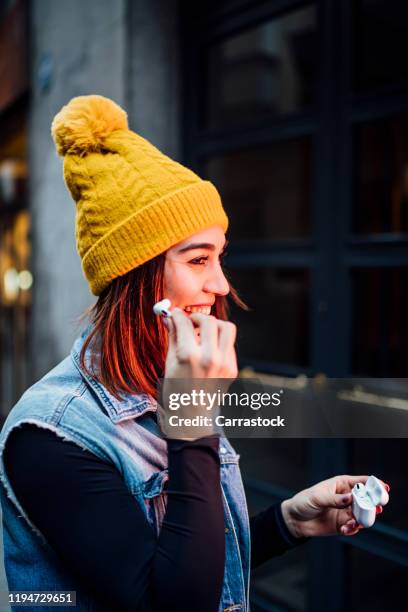 beautiful woman with yellow cap wearing wireless headphones - yellow hat stock pictures, royalty-free photos & images
