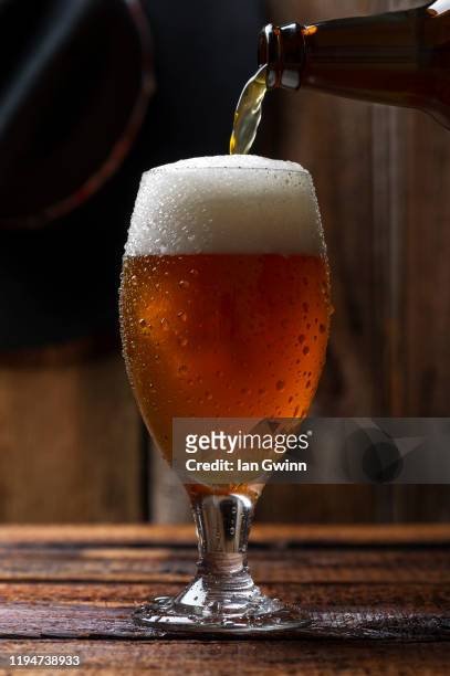 beer bottle pouring beer into beer glass_1 - ian gwinn stock pictures, royalty-free photos & images