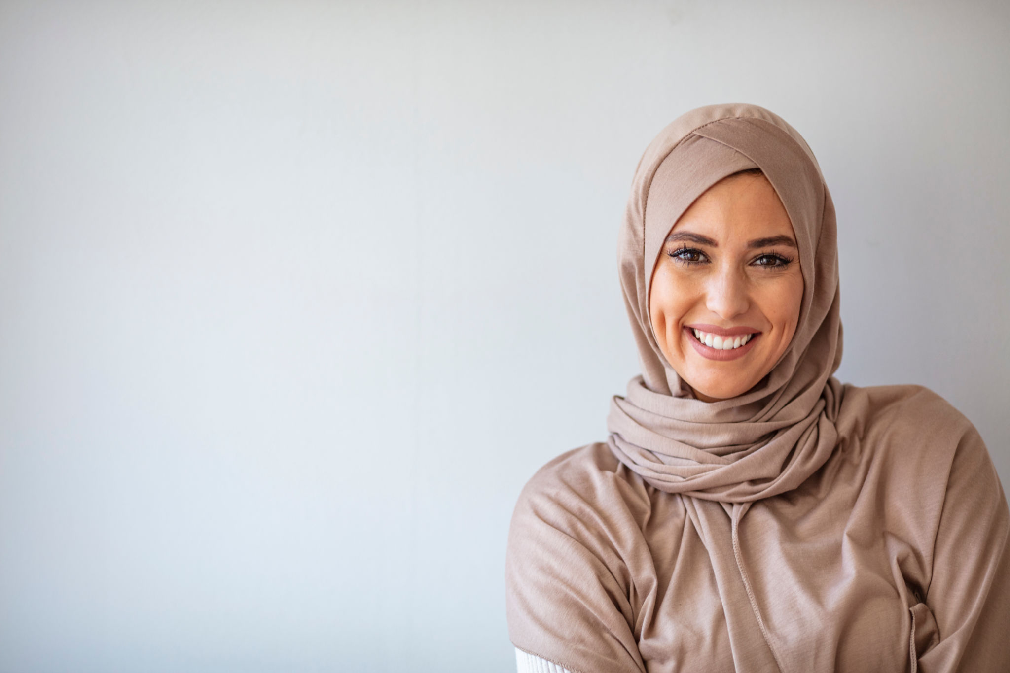 Portrait of beautiful Muslim woman on grey background. Portrait of beautiful Muslim woman on grey background.