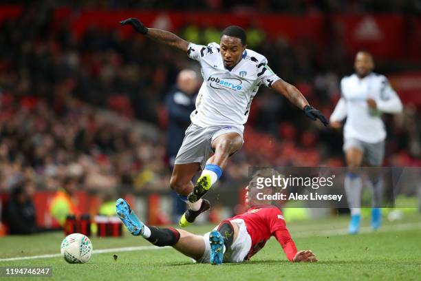 Brandon Williams of Manchester United tackles Callum Harriott of Colchester United during the Carabao Cup Quarter Final match between Manchester...