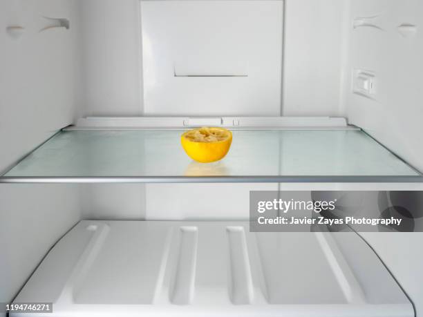 squeezed dry lemon in an empty refrigerator - réfrigérateur vide photos et images de collection