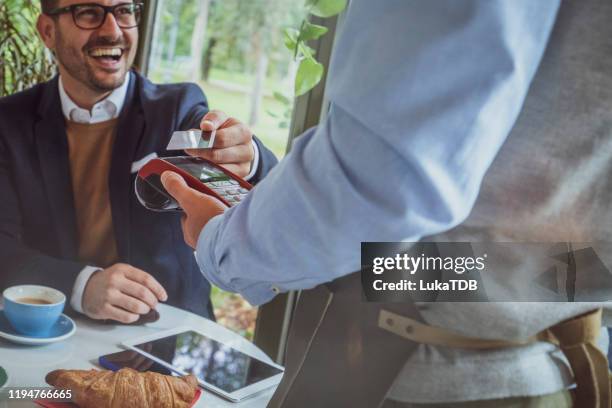 contactless credit card payment - customers pay with contactless cards imagens e fotografias de stock