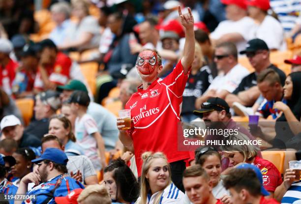 Supporters wearing superheroes costumes cheer for their team during the Vodacom Superhero Sunday rugby union match between the Vodacom Bulls and the...