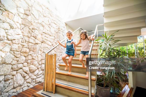 two little girls running down the stairs - child running up stairs stock pictures, royalty-free photos & images