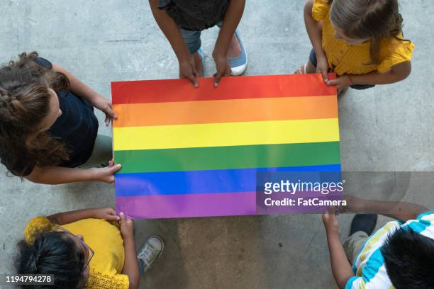 flygvy över multietniska elementära studenter som innehar en gay pride affisch stock foto - kids proud bildbanksfoton och bilder