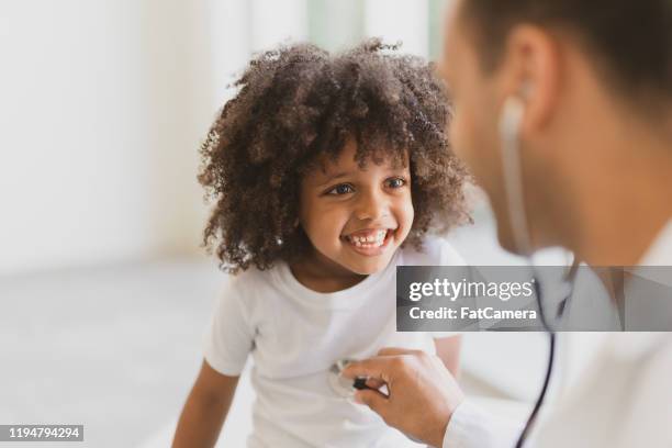 little african boy having his heart listened to stock photo - stethoscope child stock pictures, royalty-free photos & images