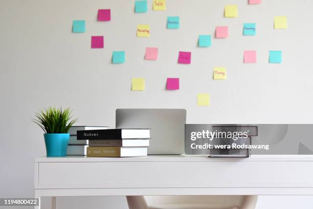 modern desk office with books stacked and computer laptop - book on table stock pictures, royalty-free photos & images