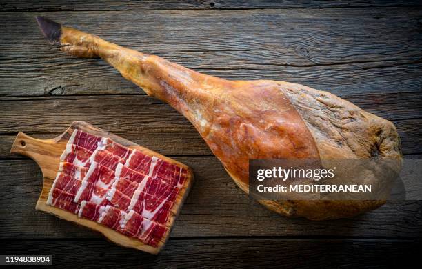 iberian ham iberic ham leg on rustic wood - iberia stock pictures, royalty-free photos & images