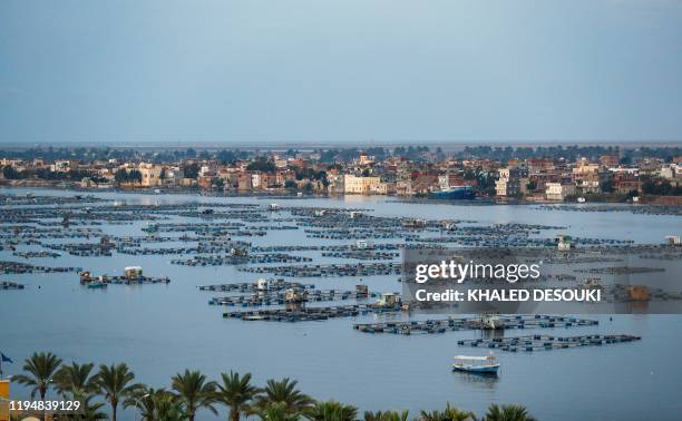 This picture taken on October 24, 2019 shows a view of a floating fish farm by the city of Rosetta on the Rosetta branch of the Nile river delta in...