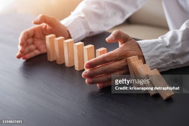 business man placing wooden block on a tower concept risk control, planning and strategy in business.alternative risk concept,risk to make buiness growth concept with wooden blocks - posicionamiento fotografías e imágenes de stock