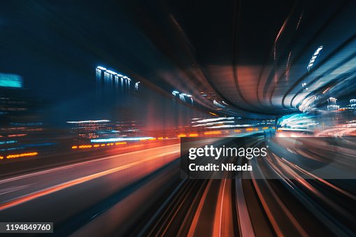 Cola de luz futurista de alta velocidad con fondo nocturno de la ciudad Cola de luz futurista de alta velocidad con fondo nocturno de la ciudad