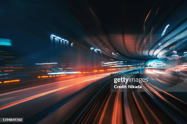 futuristica coda leggera ad alta velocità con sfondo città notturna - ferrovia foto e immagini stock