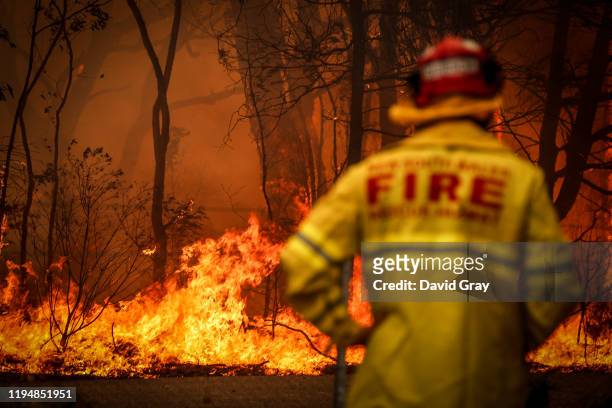 Fire and Rescue personnel watches a bushfire as it burns near homes on the outskirts of the town of Bilpin on December 19, 2019 in Sydney, Australia....