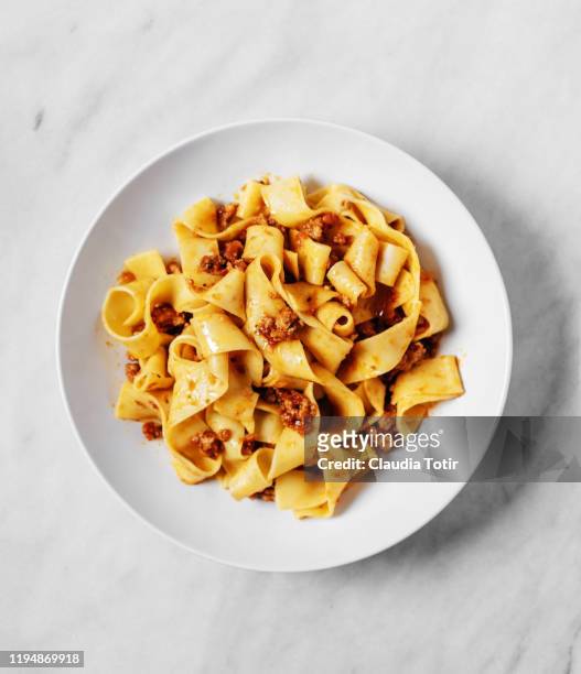 a bowl of papardelle pasta on white background - fettuccine stockfoto's en -beelden