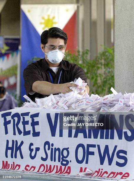 Medical worker at the Ninoy Aquino Internatoinal Airport in Manila sorts out Vitamin C packets to be distributed to returning Filipino workers from...